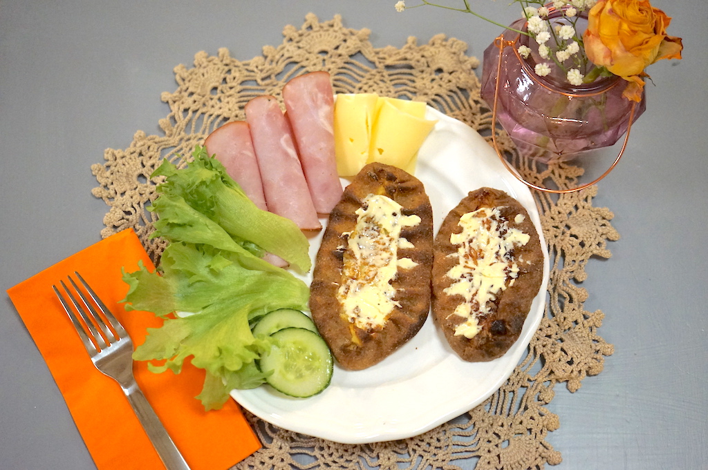 a white dish with two bread and salad